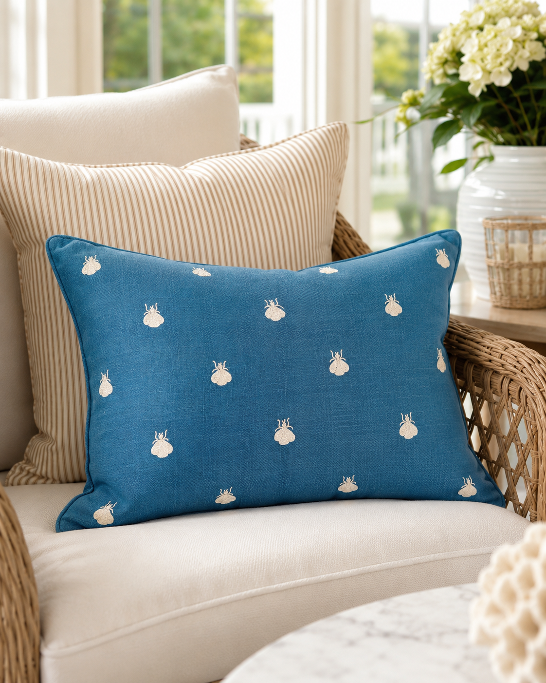 Napoleonic bee pillow in blue linen on a sunroom chair